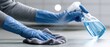 © Bi - Gloved hands spray cleaner onto surface, wiping with cloth