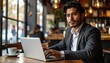 © SERENVOID - Young businessman working on laptop in coffee shop.