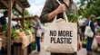 © HABIBA - Person carrying canvas tote bag with no more plastic message outdoors