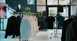 © DC Studio - Tailoring boutique filled with new designer clothing line, racks hangers with trendy merchandise and cool accessories or shoes, empty clothing store with stylish outerwear, small business.