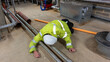 © RCH Photographic - Construction engineer in high visibility coat and hard hat has tripped over a pipe in a plant room.  Slips, trips, and falls at work affect health and safety in the workplace