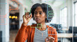 © Athena Studio - Young professional Black woman sketching a digital user interface on a clear glass board in a modern office.
