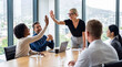 © Athena Studio - Energetic multiethnic business team celebrating a successful project with high fives in a bright office.