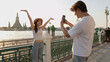 © blueringmedia - Young Couple Taking Photos by Chao Phraya River with Wat Arun Background