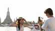 © blueringmedia - Young Couple Taking Photos by Wat Arun Temple at Sunset in Bangkok