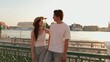 © blueringmedia - Young Asian Couple Smiling Together at Riverside Pier During Golden Hour Sunset