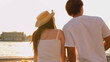 © blueringmedia - Young Couple in White Outfits Admiring Riverside Temple View at Sunset