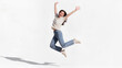 © Lumi Stock Studio - Joyful young Asian woman jumping in mid air with arms raised on white background, freedom and happiness lifestyle concept, editorial portrait photography with copy space