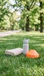 © spyrakot - Outdoor training cones, water bottle, and towel on grass in park