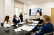 © Ladanifer - Diverse business people attending a meeting about architectural plans and 3D models