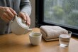 © AiPhoto - 温かいお茶を注ぐ雨の日の体調ケア