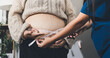 © Natchanida - Pregnant woman having her belly examined by a doctor with a stethoscope in a clinic room highlighting a medical checkup, pregnancy health, and prenatal care
