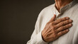 © EGSHB - Healthy senior hand over heart photo. Elderly man holding chest for cardiology medical insurance concept, gratitude prayer, cardiovascular wellness, and life care design.