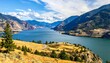 © Semoga - A serene lake surrounded by mountains and trees on a sunny day