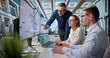 © Andrey Popov - Project Manager Leads Diverse Team Using Laptop