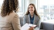 © DailyLens Studio - Female college counselor consulting with a happy teenage student in an office.