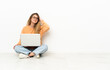© luismolinero - Young woman with a laptop sitting on the floor having doubts