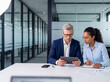 © Kin-Studio - Professional photograph of two diverse business colleagues collaborating with a digital tablet and notebook.