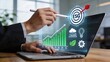 © Wei - Hand pointing to ESG target on laptop screen with green bar chart, corporate sustainability and environmental social governance business strategy concept in modern office.