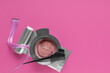 © Pixel-Shot - Hair dyeing tools with pink hair extension, color mixing bowl, brush, and aluminum foil on bright pink background