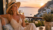 © Vyatcheslav - Smiling woman in straw hat drinking white wine on a balcony. Mediterranean coastal sunset view in Greece. Summer vacation and luxury travel concept