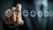 © Technically - Hand pointing to five smiley face icons rating customer satisfaction feedback on dark background