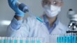 © rogerphoto - Woman scientist researcher using a micropipette to fill up test tubes with a blue liquid in laboratory setting, closeup view. Medicine and science
