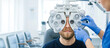 © Taras Roshchuk - A person sits in an optometrist office while a specialist adjusts a vision testing device. The room has bright lighting. The test assesses eyesight clarity and focus