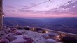 © Intan - Outdoor stone terrace lounge area overlooks a vast mountain landscape at twilight