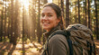 © NikProArt - Smiling young woman with a backpack hiking in a forest