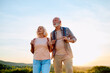 © we.bond.creations - Senior couple walking outdoors with backpacks, enjoying a healthy active lifestyle and freedom during retirement