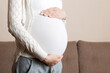 © sosiukin - beautiful pregnant woman at home while taking care of her child. maternity prenatal care and woman pregnancy concept