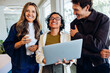 © Julia - Three coworkers share a laptop and laughs