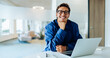 © Julia - Man with laptop smiling in an office