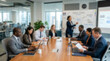 © REAL  - Soft focus blurred photo of Business team having a professional meeting in a modern office boardroom with a woman presenting ideas to her colleagues at a large wooden table