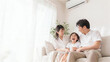 © Yka - エアコンのある白いリビングでくつろぐ夏の日本人家族