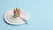 © Isabella - Miniature people standing on white target board with arrow hitting bullseye, symbolizing team success, goal achievement, strategic planning and precise marketing targeting concept