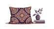 © Reginald - Home decor scene featuring a purple patterned throw pillow next to a small plant in a vase sitting on a stack of books.