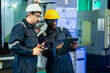 © Wanwajee - Skilled factory workers analyzing operational data on tablet computer beside industrial machinery. Engineering teamwork, predictive maintenance, process optimization, and smart manufacturing workflow.