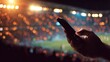 © musthofa - Person interacts with a mobile device while attending an illuminated sports event.