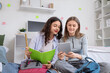 © Pixel-Shot - Female students with tablet computer studying in dorm room