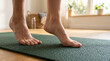 © Angavlan - Barefoot yoga practice on mat with focused feet and serene room ambiance. Yoga practice emphasizes mindful movement and balance, showcasing feet in gentle motion. Concept of yoga, wellness,
