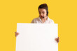 © Pixel-Shot - Female technical support agent with blank poster on yellow background