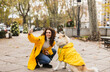 © Westend61 - Happy young woman taking selfie with dog through smart phone at footpath