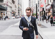 © Westend61 - USA, New York City, businessman walking in Manhattan looking at cell phone