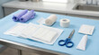 © Len_mik - Flat lay of wound dressing supplies on a blue sterile drape. Medical equipment including gloves, bandages, tape, and scissors on a clinic table. First aid preparation