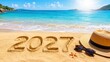 © Viktoryia - Large 2027 numbers written in golden sand beside a straw hat, sunglasses and starfish on a bright tropical beach, representing New Year travel, vacation plans and summer holidays