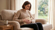 © David Zarzosa - Woman with abdominal pain holding hot water bottle on sofa at home, menstrual cramps, stomach discomfort and self care relief.