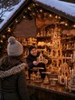 © superstock - Verkäufer präsentiert eine erzgebirgische Weihnachtspyramide auf festlich dekoriertem Weihnachtsmarkt. Traditionelle deutsche Weihnachten mit regionaler Handwerkskunst.