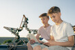 © alaa - Two young brothers concentrating on their open books on a roof, concept of homeschooling, intellectual growth and sibling hobby